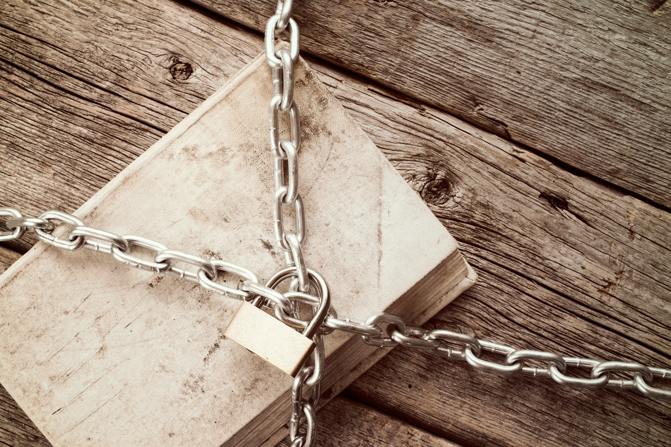 Chained Book on Wooden Background